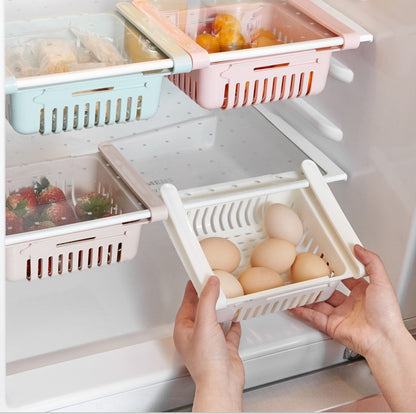 Fridge organizer with compartments holding fruits, vegetables, and eggs.