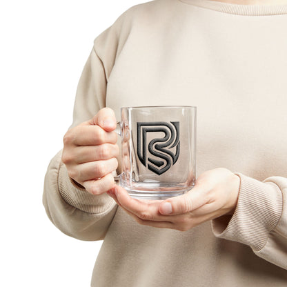 Person holding a clear mug with a logo, wearing a beige sweater.