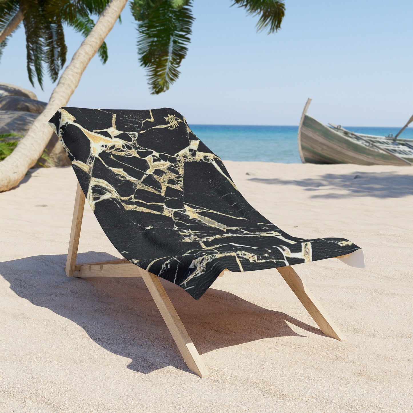 Beach chair with a black and gold patterned cover on a sandy beach with palm trees and ocean in the background.