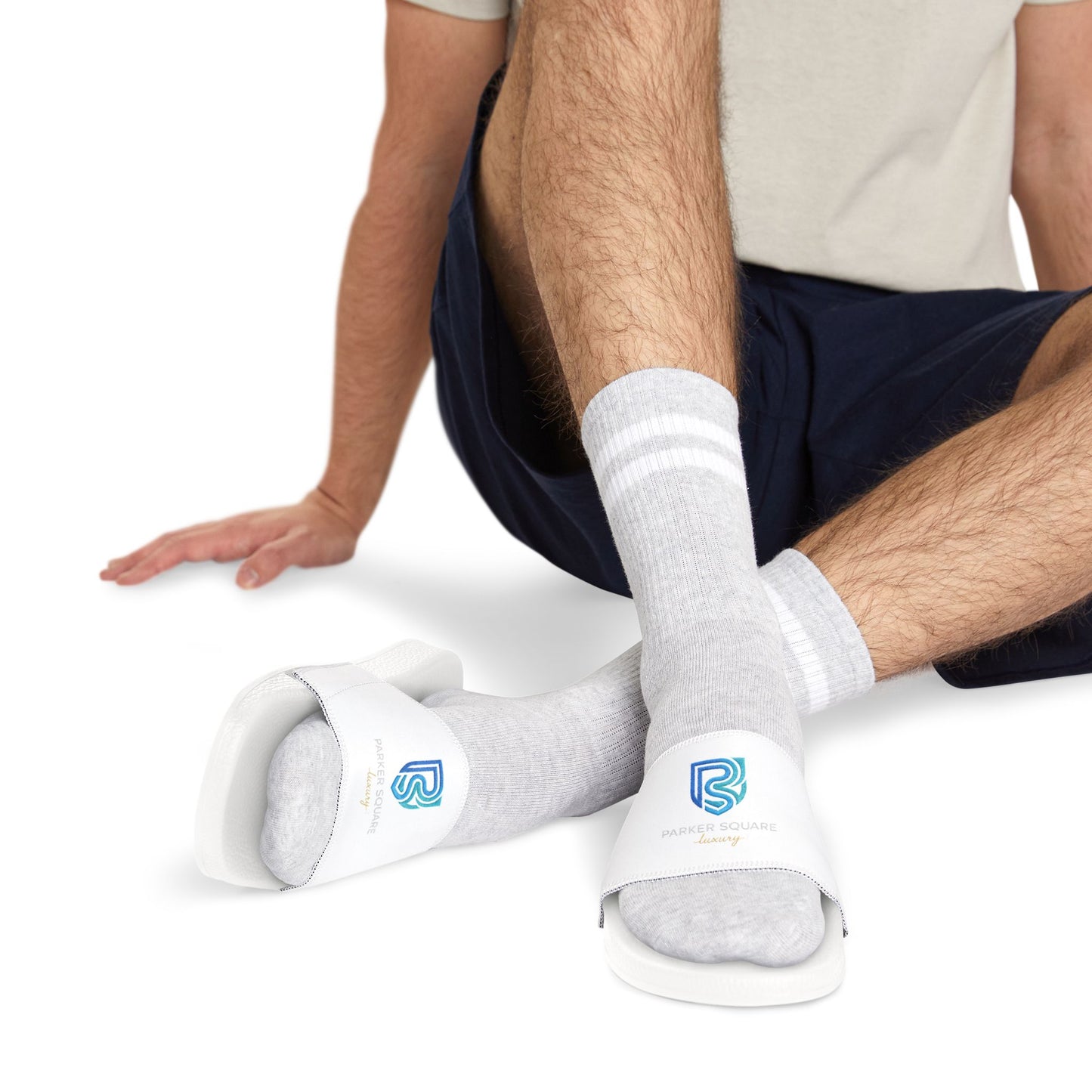 Person wearing white socks with logos sitting on a white background