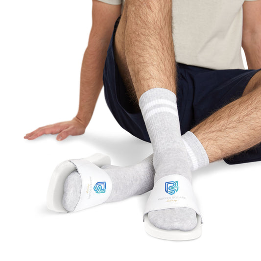 Person wearing white socks with logos sitting on a white background