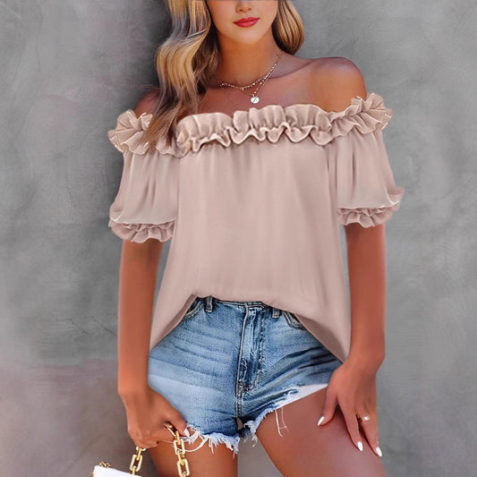 Woman wearing a beige off-shoulder top and denim shorts on a gray background